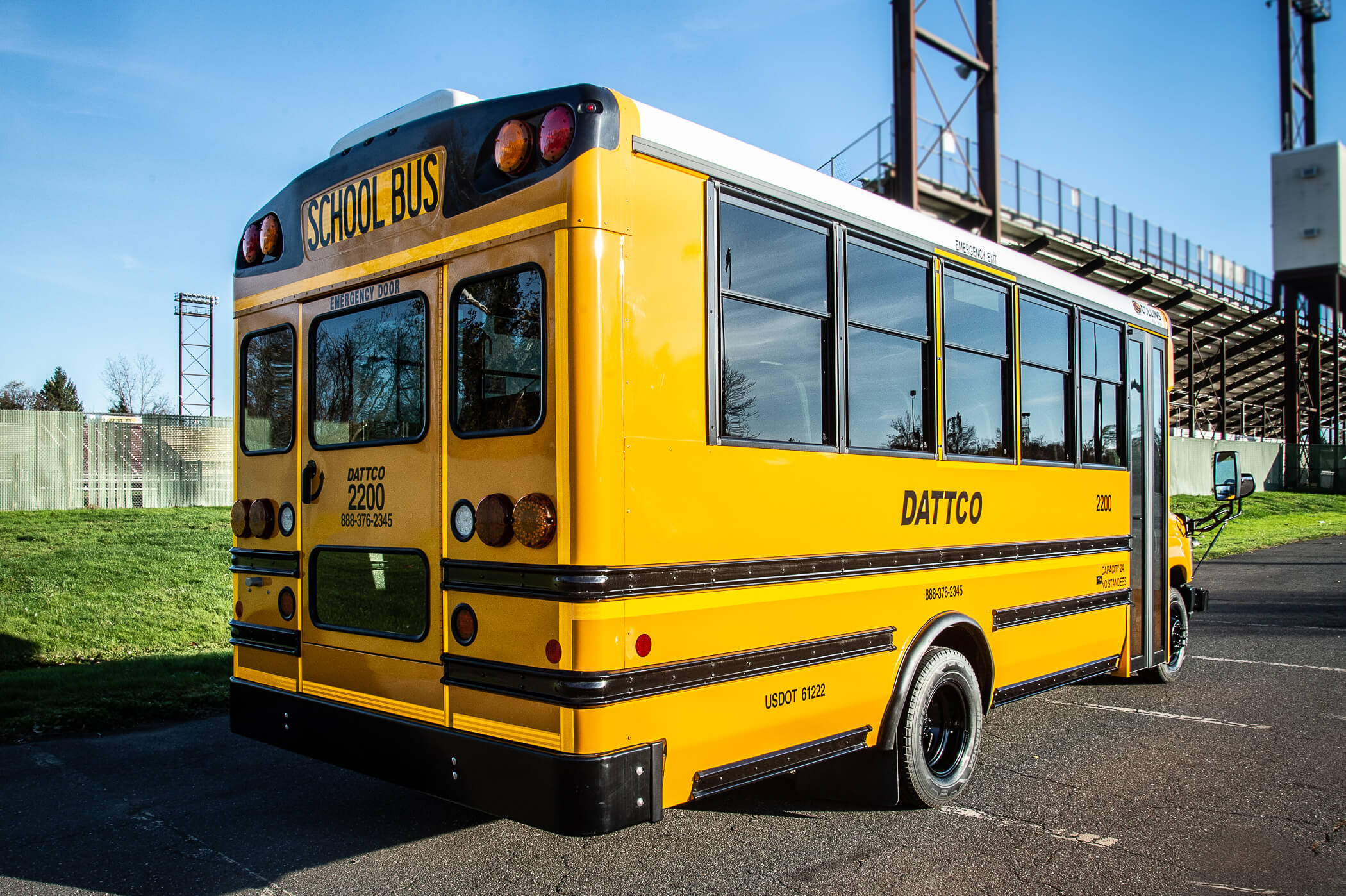 Image of a yellow school bus by a school stadium