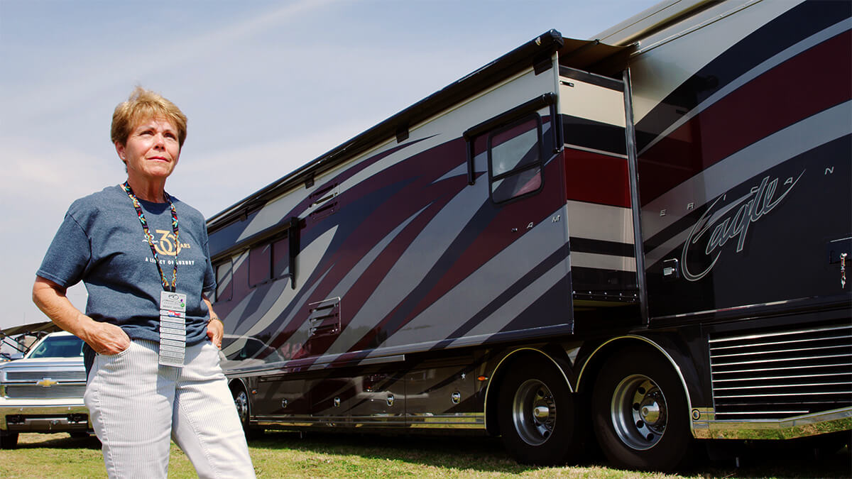 Image of a person standing in front of an American Coach RV