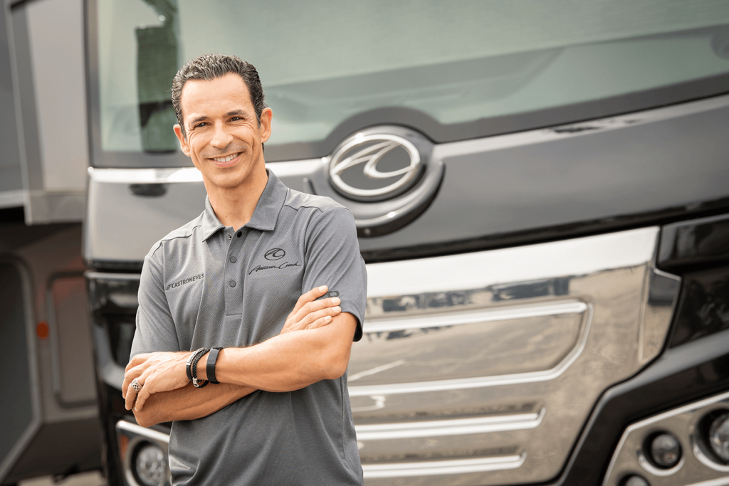 Helio Castroneves standing in front of an American Coach RV