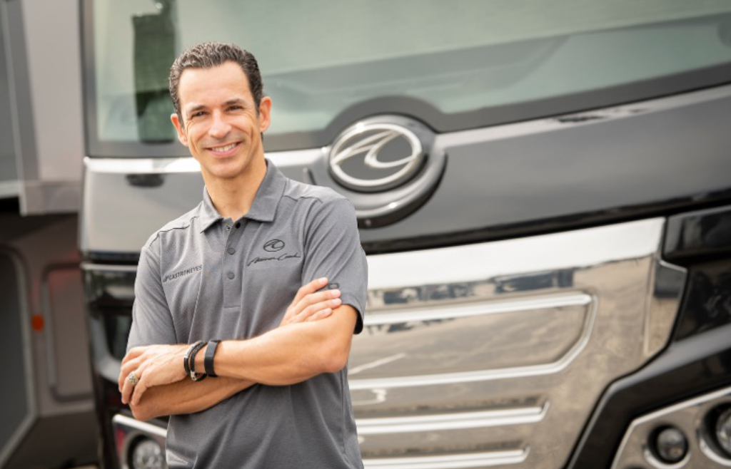 Image of Helio Castroneves standing in front of an American Coach RV