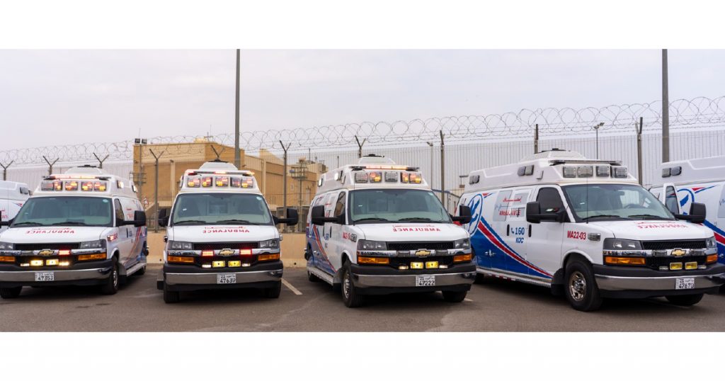 4 Ambulances in front of a fence and a building